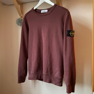 Stone Island tröja  - Säljer en sparsamt använd collegetröja från märket Stone Island. Köpt från Stone Island butiken Stockholm så kvitto finns. Inga flaws, blekningar eller liknande. Patchen på armen är även i toppskick. I övrigt en väldigt härlig och stilren färg, men tröjan kommer dessvärre inte till användning av mig längre…! Det är bara att skriva om du har frågor. (Dåligt ljus på första bilden, den är mer vinröd i verkligheten) 