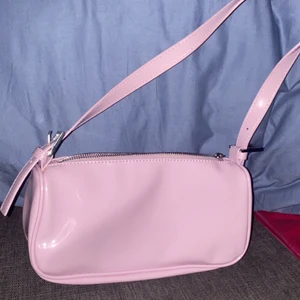 Ljusrosa axelväska i lack💕 - En snygg ljusrosa axelväska i lack med silver kedja från Ginatricot💕 Använd 1 gång så är i bra skick! köpt för 249 och säljer för 150!💕 men priset kan frtf disskuteras💓