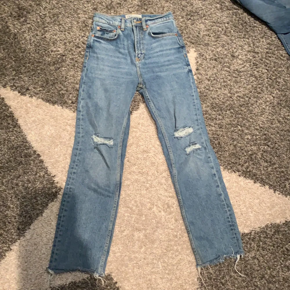 Blå vida jeans med hål på knäna.. Jeans & Byxor.