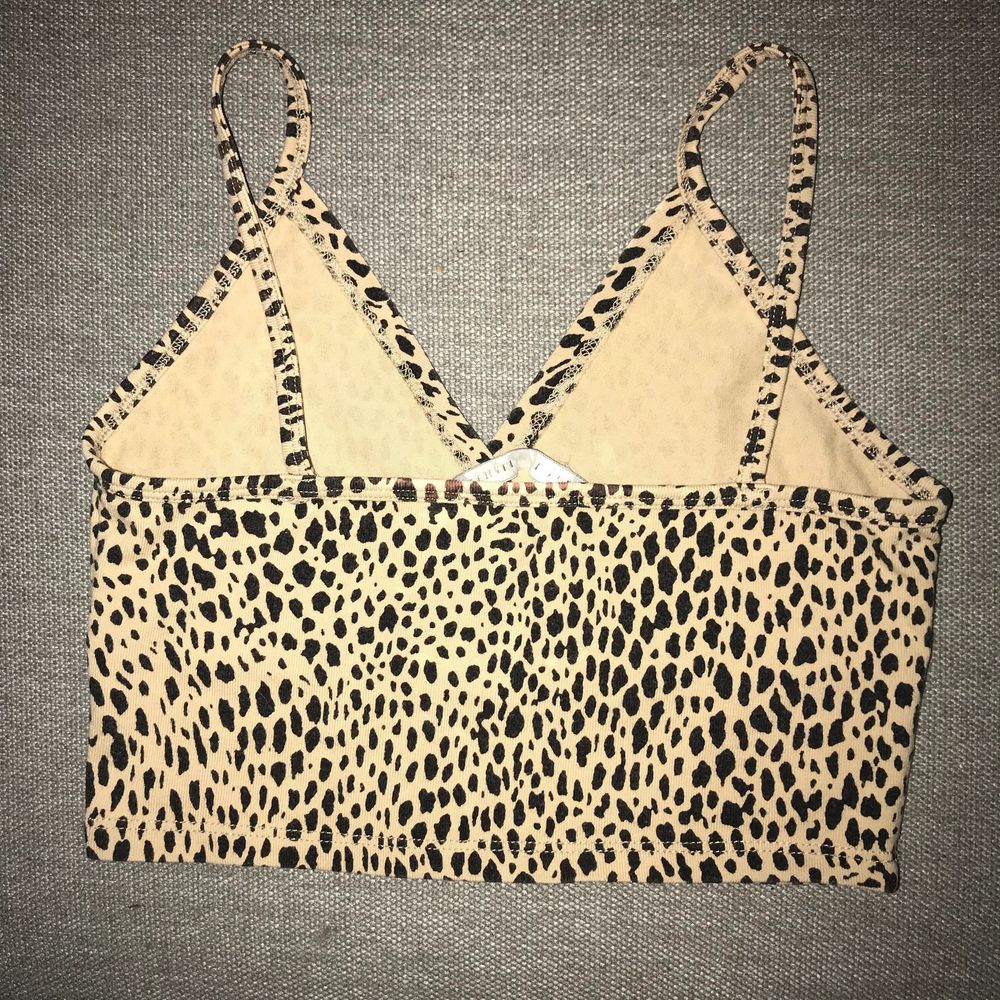 đšđšđš Purchased from a Depop seller. The tank is **NOT** mint condition. There are some discolourations on the top on the right side by the front strap (A), some fading on the straps and a couple spots on the front (B), AND on the back on the other side of the label tag (C). It is not noticeable if youâre not looking for it. Low low price reflects the flaws. đšđšđš This is too big on me on the bust area. Seems more like an S. Cotton blend crossover v-neck tank top in leopard print with a cropped fit and seam under the bust. Fabrics: 96% cotton, 4% elastane. No holes, tears, rips, pilling, loose stitching. Smoke and pet free storage space. No other flaws to note. Happy to bundle. Will gladly take more pics. Disclaimer: Please expect some general wear in all secondhand pre-owned items as they have lived a previous life, so do not expect a mint item. **TRACKED SHIPPING VIA POSTNORD**. Toppar.
