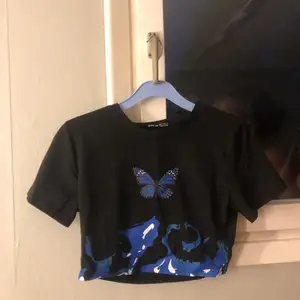 En svart tröja med blå fjärilar.Aldrig använd tyckt att den har vart för liten. Hör av er!