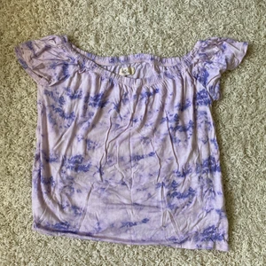Hollister off shoulder T-shirt  - Välanvänd men inga fel. Lila och rosalila spräcklig T-shirt som kan användas som vanligt och som off shoulder. Stl L men passar både M och XL