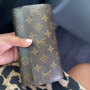 Lv handväska/plånbok - En avlång plånbok från lv. Äkta såklart knappt använt får plats med mycket innehåll, tex mobil nycklar mm