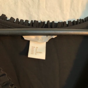 Svart klänning - Svart klänning från H&M med söta detaljer och band i sidorna. Använd 2-3 ggr. 