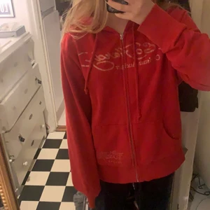 Röd ed Hardy Hoodie - Älskar den här så mycket men använder den inte längre så måste tyvärr sälja !frakteb är 66kr och den är i storlek m frakte är även spårbar !! skriv om du har någon fråga eller vill köpa !! 