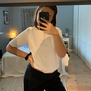 T-shirt med brodyr - Gullig t-shirt i ett jätteskönt material, skulle gissa på 100% bomull! Dessutom är det små broderade blommor på den, jättefint! Köpt second hand och vet därför inte vilken storlek den har men passar bra på mig som är 32/34/36 i överdelar. Men skulle säga att den passar dig som har typ 32-40 i överdelar!👏🏼👏🏼👏🏼❤️‍🔥