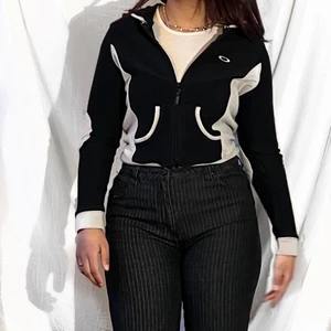 Oakley Hoodie - En supersöt, svart och beige oakley hoodie med dragkedja och armbågslappar. Stl M/L enligt etikett. Fickor fram. Sitter lite tightare i armarna och är lite mindre i storleken.  Små tecken på användning, fint skick överlag. Kunden står för frakt, som betalas separat, paket skickas så fort som möjligt. Meddela gärna om du har frågor eller vill se fler bilder. 