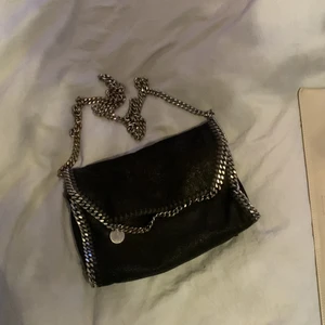 Liten Stella McCartney väska - Super gullig svart Stella McCartney väska ÄKTA. Har tyvärr inte kvar kvitto eller dustbag. Den har ett litet hål på undersidan som inte syns när man har den på sig. Köparen står för frakten 66kr brukar den vara på. 