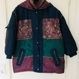 Dunjacka strl M - Oversized dunjacka i strl M, köpt second hand i Berlin. Går i grönt, blått och lila, skimrar lite. Perfekt festjacka men även till vardags. Kan även passa andra storlekar beroende på hur stor man vill ha den. Har luva. 50% dun 50% fjädrar. Fint skick! 