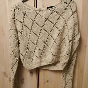 Stickad croppad kofta  - Beige stickad croppad kofta med knappar i ryggen. Från Vero moda strl S. Köparen står för frakt 