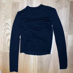 svart tröja, storlek XS - en svart tunn tröja med en liten tunn krage. Från gina tricot. Använd 1/2 gånger för ca 2/3 år sen. Lite vågit material vid ärmarna och nere vid tröjan. 