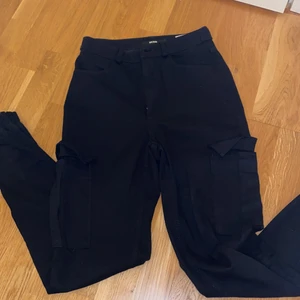 Byxor med fickor på sidan - Svarta byxor med fickor på låren. Köpare står för frakt.