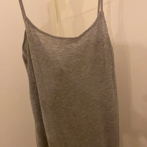 Grå långklänning - Grå långklänning med en snygg klippning nertill vid vänster ben. Används en sommar. Köpare står för frakt. 