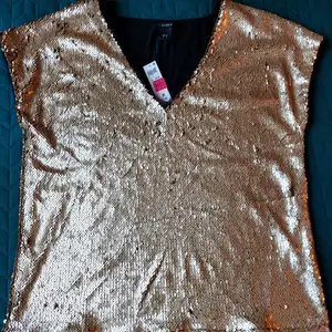 Brand new blouse from Lindex. Never worn, with price tags in place. Clean, no defects.  Beautiful semi-mat golden sequins on the entire front. Black plain fabric on the back.  Lining under the front.  Fabric: 95% viscose, 5% elastan.  Size: M (for loose fit, per info on the tag), fits L too (closer to body).