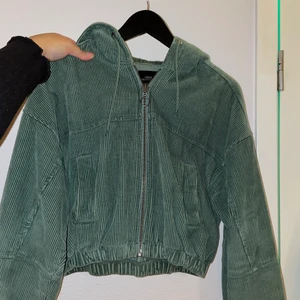 Urban outfitters jacka i Manchester  - Grön Manchester jacka/kofta från Urban outfitters! Är i fint skick! Nypris 700kr, säljs för 350kr🥳 Storlek S, passade inte mig som har storlek L🥲