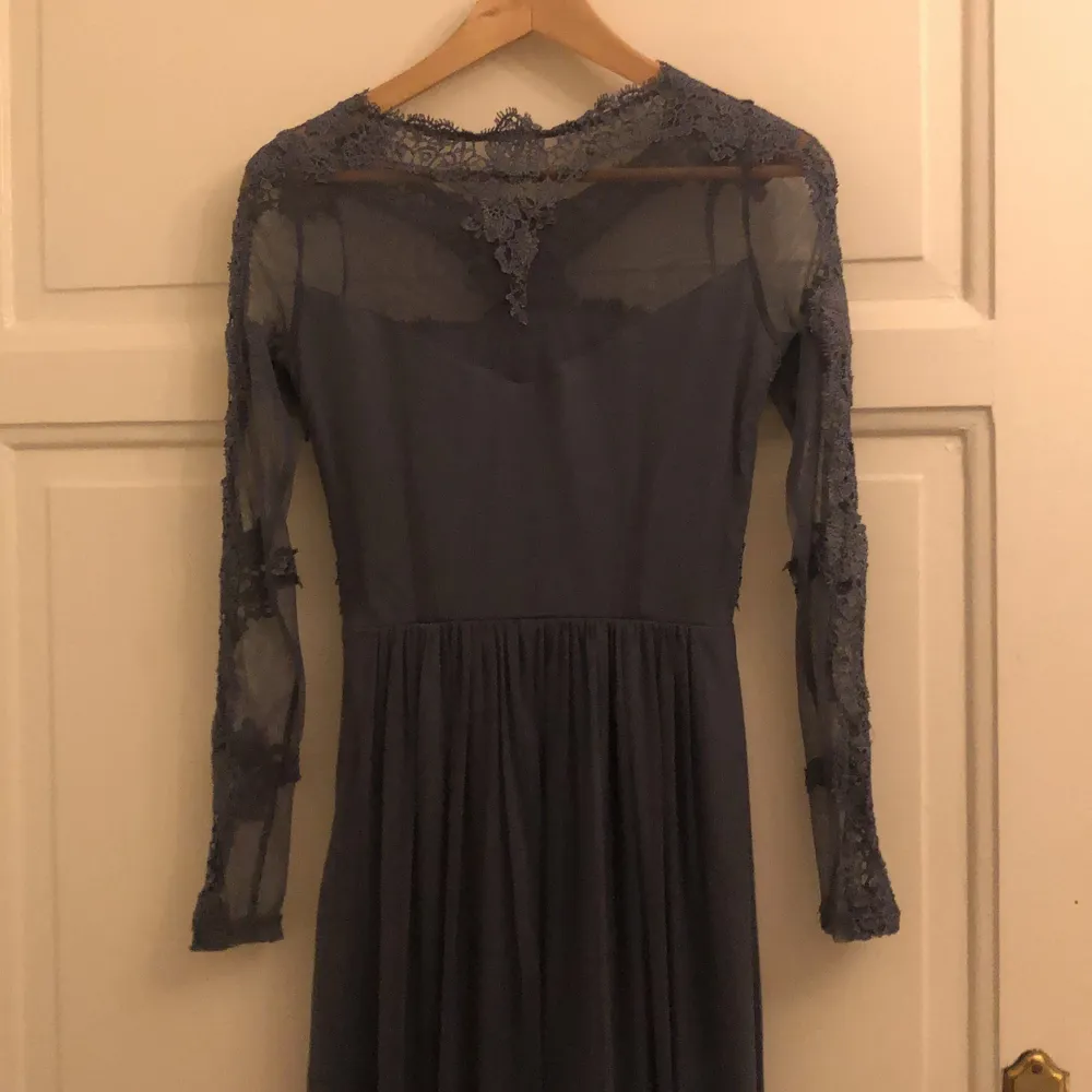 Grå blå klänning med typ och spätts detaljer. Jag är 162cm lång och passar bra.. Mekot.