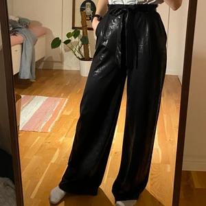 Vida svarta läderbyxor - Vida läderbyxor med knytskärp i midjan. NLY strl xs. Jag är 165cm lång. 