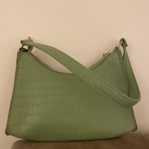 Säljer en grön handväska