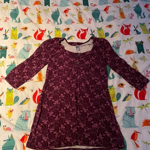 Mönstrad tunika - Säljer en gullig mönstrad vinröd/lila tunika, en kortare klänning! Söta knappar uppe vid bysten i skönt material