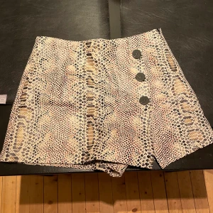 Beige kjol/shorts i ormmönster - Säljer min kjol med byxben från Zara. Strl S. 50kr +frakt