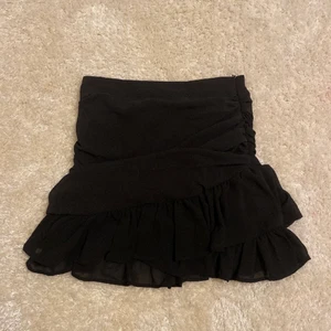 Svart volangkjol - Säljer nu min svarta volangkjol som tyvärr inte har kommit till användning. Den är använd 2-4 gånger max. 