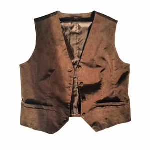 Brun kostym väst i velour - En brun väst I gott skick, pris går att diskutera. Västen är i en mörk brun färg och har storleken 42. Den är gjord av 98% Bomull och 2% Spandex.