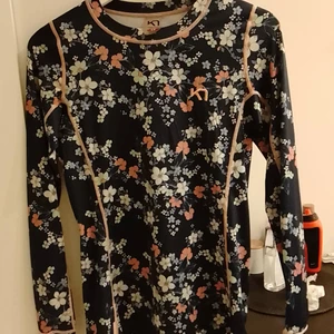 Underställ s tröja från karitraa st smal - Snygg och riktigt bra underställ s tröja som håller dig varm, som ny använd sparsamt, blå med rosa, grå blommor på. 