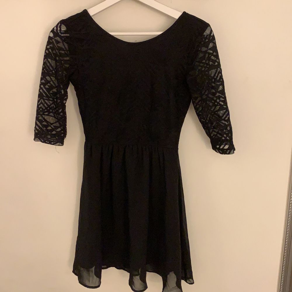 En svart klänning med trekvartsärmar, detaljer upptil och transparenta ärmar från H&M, divided, med tunt tyg nedtill. Strl 34.. Klänningar.