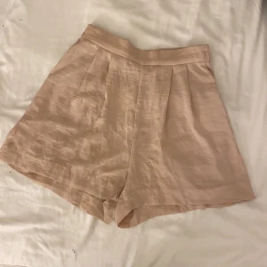 Högmidjade sidenshorts - Gammalrosa shorts i siden med superhög midja och resår. Köpta från HM i storlek 32. Finns små fläckar i bak som knappt syns när man har de på sig (bild 2 eller 3). Gratis frakt! 