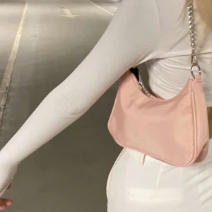 Rosa väska - Nasse Vårkollektionen är nu ute och detta är vår gameldags-ljusrosa baguette väska med silver detaljer och avtagningsbara band. Väskan är i polyester material. Väska med originalband 250kr. Väska med både originalband & kedjeband 300kr.