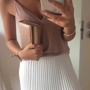 Plisserad kjol vit - Så snygg vit plisserad kjol som går över knäna! (Säljer även linnet på bilden) Använd enstaka gånger så fint skick. Köptes på Chelsea. Svart resårband och dubbeltyg en bit som ni ser på andra bilden så den inte blir genomskinlig! Jag är 165cm lång och frakt tillkommer 💞 Hör av er vid frågor/prisförslag!🥰  När jag kollar noga så ser jag lite småsmå fläckar men inget man lägger märke till annars, har inte använt på länge så försvinner säkert i tvätten - säg till så kan jag tvätta den innan leverans!