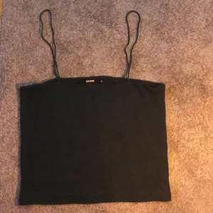 Topp - Mörkgrön croptop med smala band. Aldrig använd då den är för stor för mig.. 