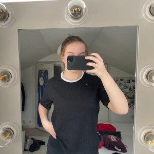 Svart t-shirt med vit halsringning  - Svart T-shirt med vit halsringning från ASOS. Knappt använd, bra skick. Spårbar frakt med DHL inräknad i priset!!