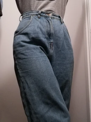 Baggy jeans - Jeans från NA-KD. Högmidjade, tighta i midjan men sitter annars löst. Jag är 160 cm och skulle säga att de är lite för långa på mig, så passar säkert bättre på någon som är något längre. De är i bra skick, utan slitningar. Kan mötas upp eller ev. Frakta😊