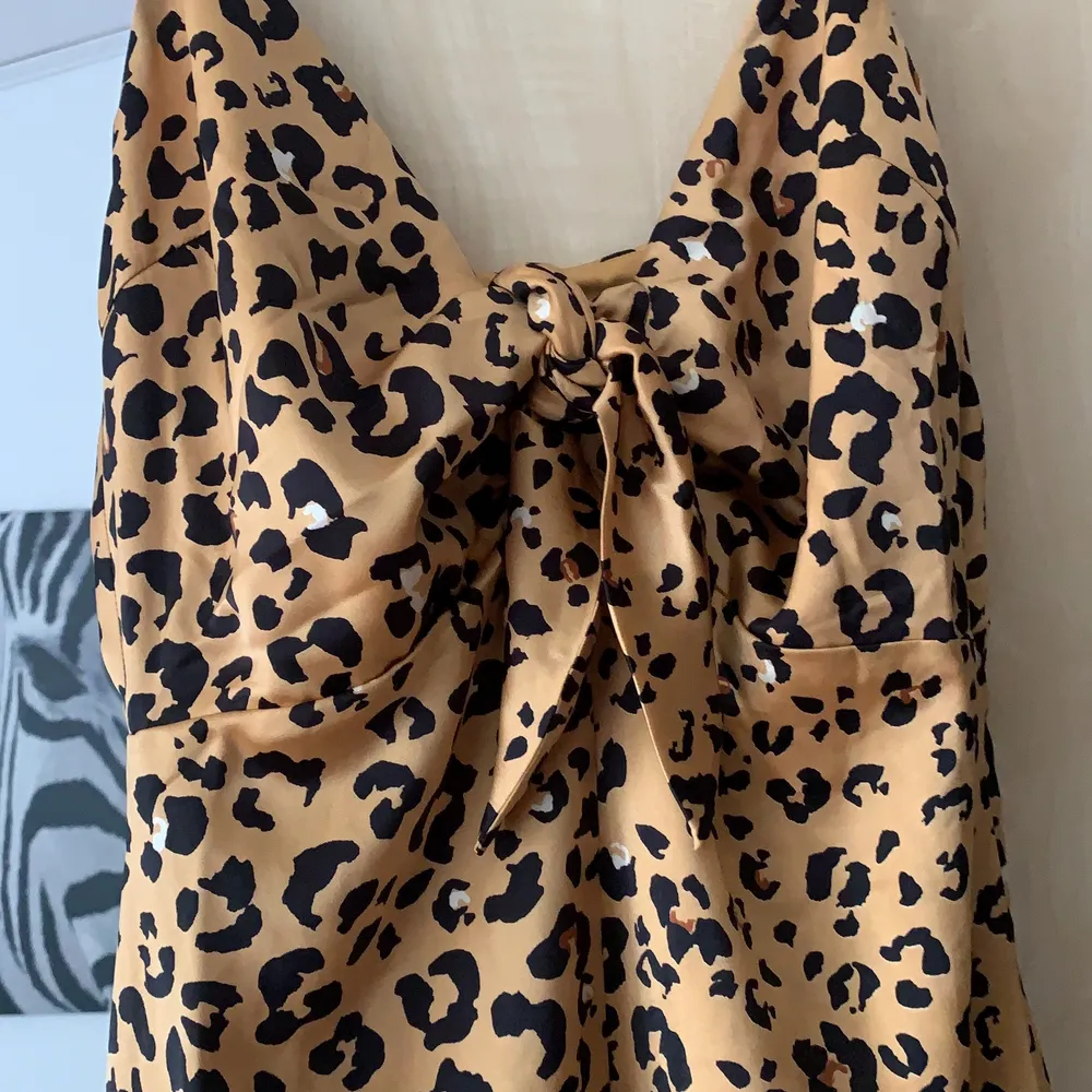 Klänning i sidenmaterial, leopard mönster med knyt fram. Längre modell! Aldrig använd . Klänningar.