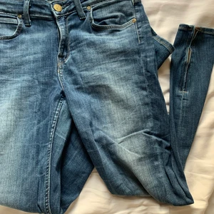 Lee jeans - Lee jeans i scarlett cropped modell. De är tighta hela benen och stretchiga i modell. De har dragkedja längts ner på benen. Använda få gånger. Storlek W29 L33 passar mig i läng som är 165. Passar storlek M
