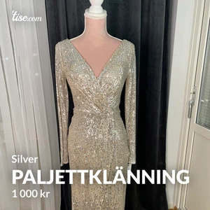 Silver paljettklänning  - Silver paljettklänning med slits. Öppen rygg & går att knäppa till vid brösten(se i bifogad bild). Finns i storlek 40.  Helt ny & prislapp finns. Vid önskemål  kan jag skicka en video på klänningen för en bättre helhet!  Observera att den är ganska liten i storlek. Gå upp i en storlek vid intresse!