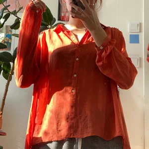 Orange blus  - Orange mesh blus, längre i ryggen än framsidan. Knappar hela vägen ner