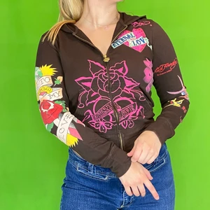 Ed Hardy  - Ed Hardy zip up hoodie i toppenskick! Brun med rosa detaljer. Storlek M. Knappt några kristaller saknas. Modellen använder vanligtvis storlek S / M och är 169cm. Axel till axel 37cm, ärm längd 58cm och längd 53cm. Spårbar frakt är inräknad i priset. 