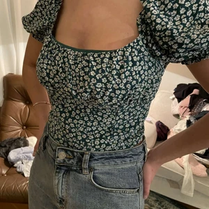 Blommig sommartopp - Så fin topp i en härlig grön färg med söta vita blommor🥰 Storlek 40 men den är liten i storleken. Skriv för fler bilder!