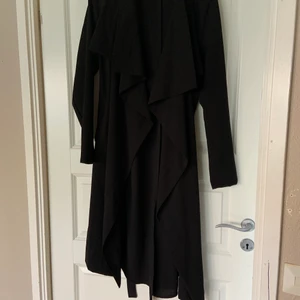 Kappa - Tunn kappa från ett designföretag, de är storlek M. Aldrig använt den men klippt bort lappen i nacken, lång kappa med knyte i midjan