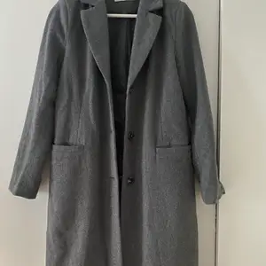 Knappt använd kappa i grå färg bra skick från NLY
