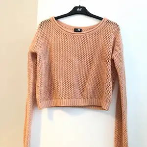 En peach färgad nät-tröja som är en croppad model, i storlek M