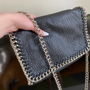 Supersnygg väska från Tiamo  - Supersnygg och mycket sparsamt använd axelremsväska från Tiamo köpt på Scorett för några år sedan. Säljes pga att den ej kommer till användning. Inga defekter alls = i nyskick. Kan användas på olika sätt 🌸✨ MÅTT: 27x18 cm ✨🌸 Buda 💗