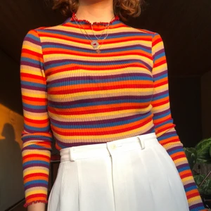 Färgglad croppad tröja med mock neck - Säljer en knappt använd, ribbad mock-neck tröja! Från Dollskill. Figurnära men samtidigt superskön, passar S/XS. Frakten ingår i priset! Bara att kontakta mig om du har några fler frågor om plagget☺️✨