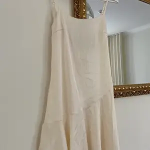 Snygg benvit klänning i satin från NastyGal! Storlek small och aldrig använd, kort passform