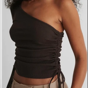 Oneshoulder brun topp - Topp från NA-KD, aldrig använd. Original pris 249kr.
