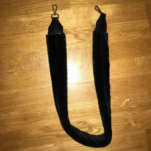 Carin Wester axelrem - Axelrem till handväska med svart fuskpäls från Carin Wester, knappt använd. Ej justerbar, ca 90cm lång