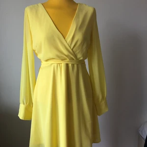 Söt gul klänning  - Knytning runt midjan. Knäppning vid ärmen. 