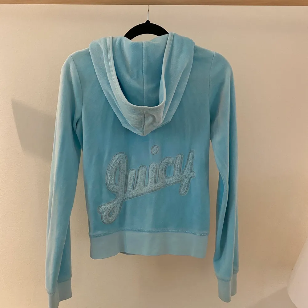Ljusblå Juicy Couture hoodie med logga där bak i froté-material. Koftan är i bra skick och är knappt använd. Superfin ljusblå färg som passar perfekt till våren och sommaren!🤗💞. Hoodies.